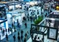 This photo captures the dynamic atmosphere of a trade show in full swing, showcasing an array of exhibitors and attendees. Under the bright lights of the venue, businesses and industry professionals gather to display their latest offerings, share insights, and create valuable connections. The strategic layout of the booths enhances visibility and facilitates interaction, making it an ideal environment for networking, learning, and fostering growth opportunities within the industry.