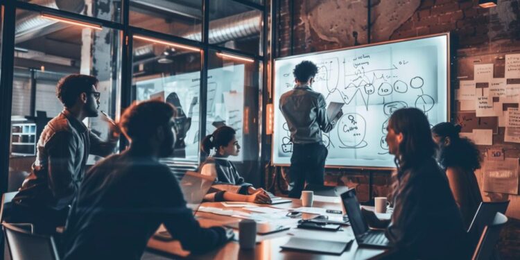 In the warm glow of the evening, a diverse and attentive team gathers around the conference table, eyes keenly focused on the presenter. The presenter, standing confidently, leads a lively discussion, pointing to the whiteboard filled with diagrams and notes that reflect the innovation at the heart of the company's culture. As ideas flow and strategies take shape, it's clear that this is a moment where collaborative minds are crafting the blueprint for future success.